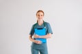 Portrait of positive young female physician in medical uniform holding clipboard and looking at camera. Royalty Free Stock Photo