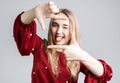 Portrait positive of young woman with long blonde hair with cheerful expression. Gesturing finger frame Royalty Free Stock Photo
