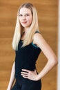 Portrait of positivity and pretty blonde girl in black sportwear smiling at camera and posing, holds hand on waist in the gym. Con Royalty Free Stock Photo