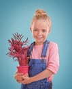 Portrait, pot and plant with girl, kid and happiness with smile on a blue studio background. Face, mockup space or model Royalty Free Stock Photo