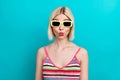 Portrait of pouty lips funny playful girl flirting humorous wear sunglasses with trendy striped singlet  on blue Royalty Free Stock Photo