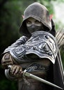 Portrait of a powerful armored,silent, dark elf assassin archer masked and cloaked in secrecy and equipped with a dagger. Royalty Free Stock Photo