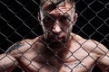 Portrait of a powerful fighter behind the steel bars of the octagon. The concept of sports, Muay Thai, martial arts Royalty Free Stock Photo