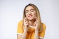 Portrait of praying young woman wearing casual clothing begging god please looking up with keeping fingers crossed Royalty Free Stock Photo