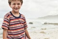 Portrait of a preadolescent boy smiling while standing at beach Royalty Free Stock Photo
