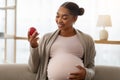 Portrait of pregnant african american woman holding red apple Royalty Free Stock Photo