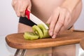 Portrait of pregnant mother cuts kiwi fruit Royalty Free Stock Photo