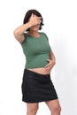 Portrait of a pregnant woman covering her eyes and hand on belly on white background Royalty Free Stock Photo