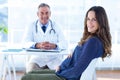 Portrait of pregnant woman with male doctor in clinic Royalty Free Stock Photo