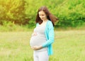 Portrait of pregnant young woman outdoors in warm summer