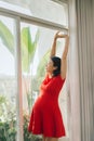 Portrait of pregnant young woman stretching joyfully standing in livingroom lit by warm sunlight, copy space Royalty Free Stock Photo