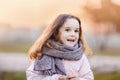 Portrait of a preschool girl in autumn in warm clothes and a scarf