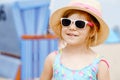 Portrait of preschool girl in colorful swimmsuit and straw hat. Cute happy toddler child on family vacations on the sea Royalty Free Stock Photo