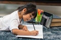 Portrait of preschool kid using tablet for his homework,Soft focus of Child doing homework by using digital tablet searching Royalty Free Stock Photo