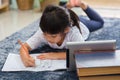 Portrait of preschool kid using tablet for his homework,Soft focus of Child doing homework by using digital tablet searching Royalty Free Stock Photo
