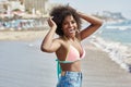 Pretty afro american girl standing in sea breeze raising hands l Royalty Free Stock Photo