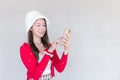 Portrait of a pretty Asian teen girl wearing a red dress and white hat happily using a smartphone on a white background Royalty Free Stock Photo