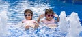 Portrait of pretty asian twins smilling and posing on swimming pool background wearing pink swim suit and sun glasses Royalty Free Stock Photo