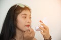 Portrait of pretty Asian woman applies red lipstick . Hand of make-up master, painting lips of young beauty model female. Royalty Free Stock Photo