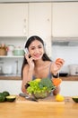 A pretty Asian woman is smiling at the camera, enjoying the music while preparing her breakfast Royalty Free Stock Photo