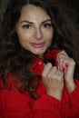 Portrait of a pretty, attractive woman in a red overall leaning against a tree trunk Royalty Free Stock Photo