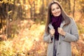 Portrait of a pretty attractive young woman with brown hair in a fashionable coat and burgundy scarf outdoors. A Royalty Free Stock Photo