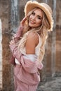 Portrait of a pretty, beautiful and romantic smiling young woman with long loose blonde hair in a straw hat. Countryside landscape Royalty Free Stock Photo
