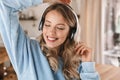 Portrait of pretty blond girl 20s wearing headphones listening to music at home Royalty Free Stock Photo