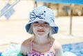 Portrait of pretty blond toddler girl wearing elegant blue panama near the pool Royalty Free Stock Photo