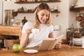 Portrait of pretty blond woman reading book and drinking coffee while sitting in cozy cafe indoor Royalty Free Stock Photo