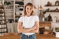 Portrait of pretty blond woman smiling and rejoicing while standing in stylish wooden kitchen at home Royalty Free Stock Photo