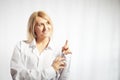 Portrait of a pretty blonde smiling woman posing on a white background and pointing somewhere. Happy girl model in white Royalty Free Stock Photo