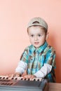 Cute boy wearing baseball cap backwards playing the digital piano Royalty Free Stock Photo