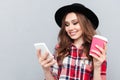 Portrait of a pretty casual woman in hat typing message Royalty Free Stock Photo