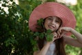 Portrait of pretty cheerful woman wearing white dress and straw pink hat in sunny warm weather day Royalty Free Stock Photo