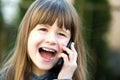 Portrait of pretty child girl with long hair talking on cell phone. Little female kid communicating using smartphone. Children Royalty Free Stock Photo