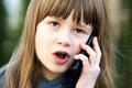 Portrait of pretty child girl with long hair talking on cell phone. Little female kid communicating using smartphone. Children Royalty Free Stock Photo