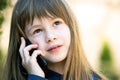 Portrait of pretty child girl with long hair talking on cell phone. Little female kid communicating using smartphone. Children Royalty Free Stock Photo