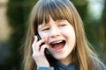 Portrait of pretty child girl with long hair talking on cell phone. Little female kid communicating using smartphone. Children Royalty Free Stock Photo