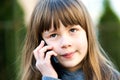 Portrait of pretty child girl with long hair talking on cell phone. Little female kid communicating using smartphone. Children Royalty Free Stock Photo