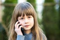 Portrait of pretty child girl with long hair talking on cell phone. Little female kid communicating using smartphone. Children Royalty Free Stock Photo