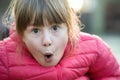 Portrait of a pretty child girl making amazed shoked expression on her face outdoors Royalty Free Stock Photo