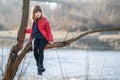 Portrait of a pretty child girl sitting on a tree branch in autumn outdoors Royalty Free Stock Photo