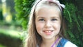 Portrait of pretty child girl standing in summer park looking in camera smiling happily Royalty Free Stock Photo