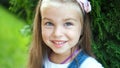 Portrait of pretty child girl standing in summer park looking in camera smiling happily Royalty Free Stock Photo