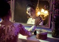 Portrait of a pretty countess touching an antique mirror