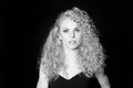 Portrait of a pretty curly blonde woman, wearing black dress Royalty Free Stock Photo