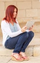 Portrait of a cute expressive redhead woman reading information on its touch pad Royalty Free Stock Photo