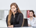 Portrait of pretty female helpdesk employee with headset at workplace. Royalty Free Stock Photo