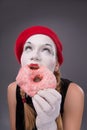 Portrait of pretty female mime eating a tasty pink Royalty Free Stock Photo